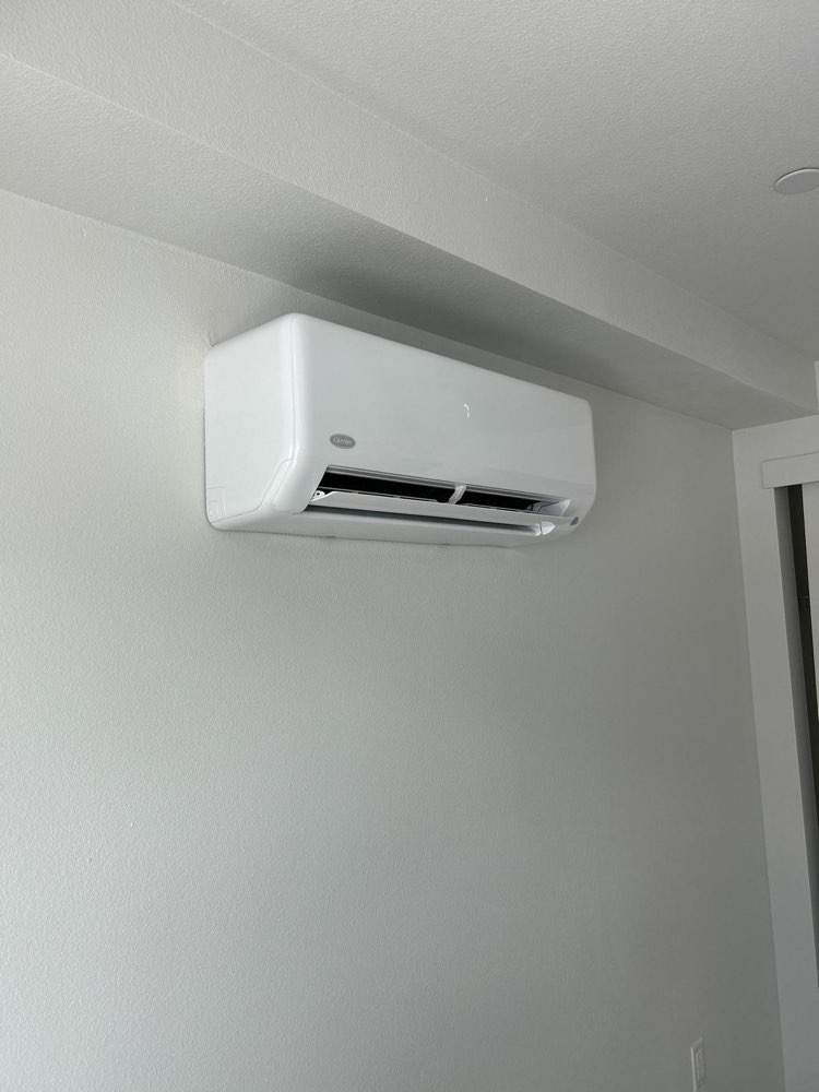 White wall-mounted mini-split indoor unit on a light-colored wall.